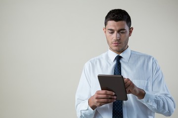 Businessman using digital tablet against white background