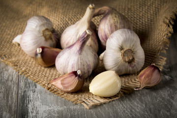 Close-up garlic bulbs and garlic cloves on wooden background