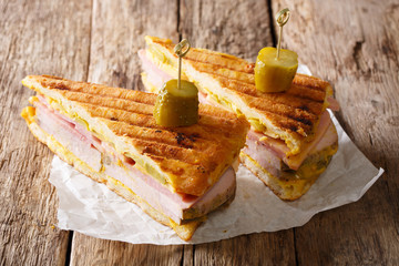 Cuban sandwich with ham, mustard, cheese, pickled and pork close-up. horizontal