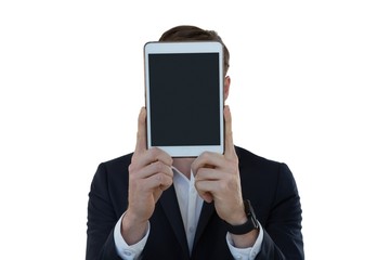 Businessman hiding his face with digital tablet