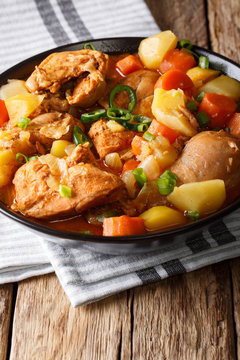 Spicy chicken stew with vegetables close-up on the table. vertical