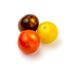 Three colorful fresh cherry tomatoes on white