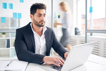 Fototapeta premium Busy employer with laptop looking through new resume of applicants