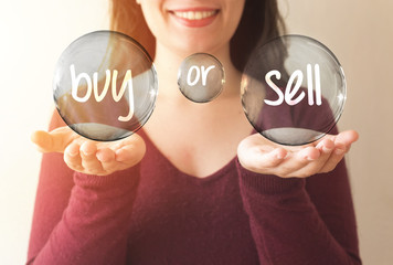 business woman holding transparent bubble with buy or sell text