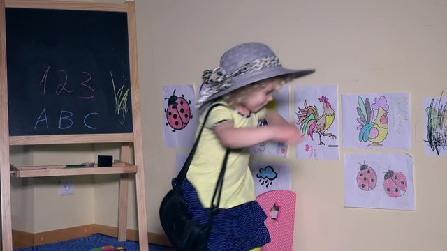 cute little model girl showing fashion with hat and handbag