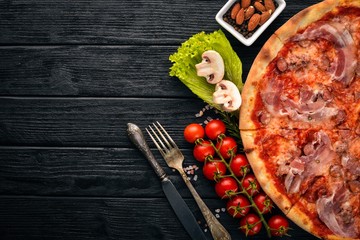 Pizza Lardon. Bacon, cherry tomatoes, sausage salami. On a wooden background. Top view.