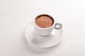 Espresso coffee cup on a white wooden background. Top view. Free space for text.