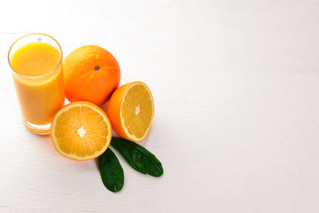 Orange fresh juice and oranges on a wooden surface. Top view. Free space for text.