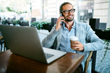 Work From Cafe. Man Talking On Phone Working In Cafe