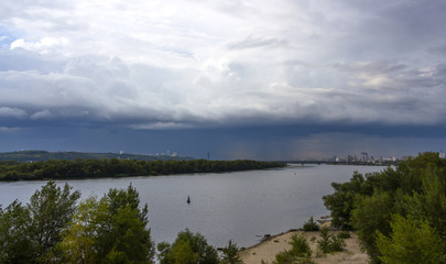 Heavy, stormy clouds of contrasting color over the evening city