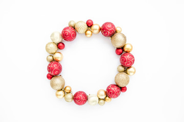 Holiday round frame made of red and gold glass Christmas balls isolated on a white background. the apartment lay, top view