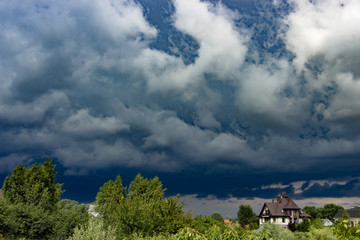 Heavy, stormy clouds of contrasting color over the evening city