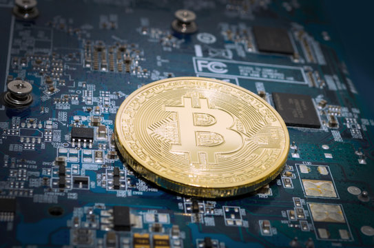 golden bitcoin on circuit board
