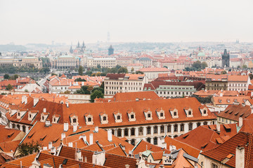 Fototapeta na wymiar A view from above on the roofs of houses and beautiful architecture in Prague in the Czech Republic.