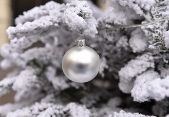 Boule de Noël argent dans sapin enneigé