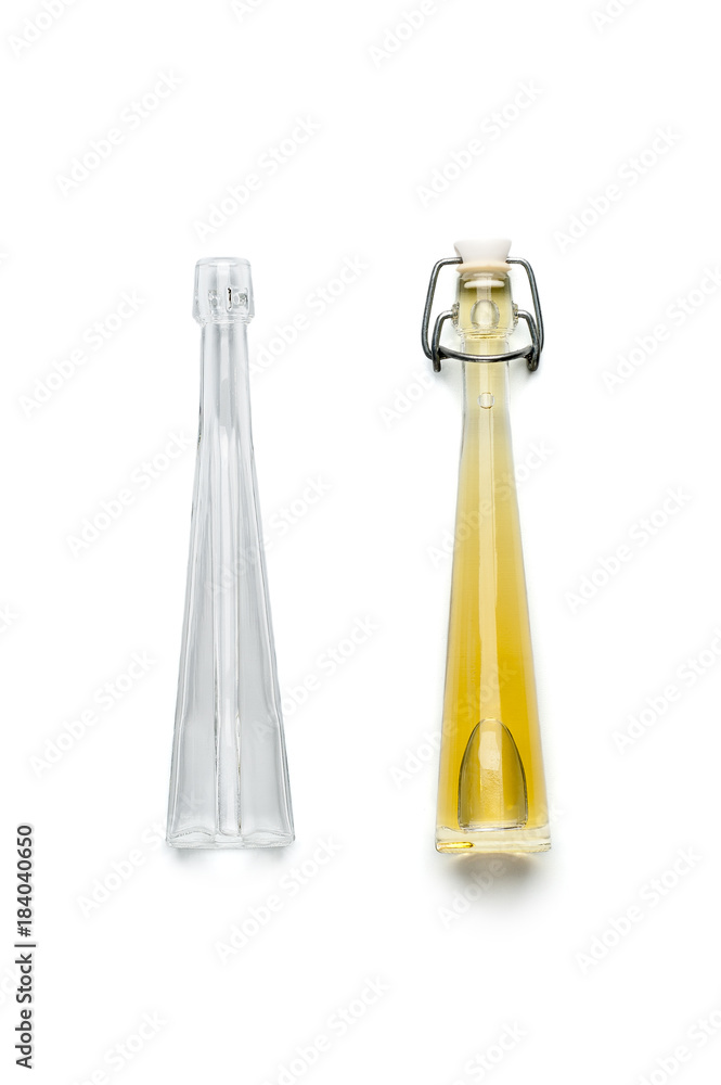 Wall mural a glass bottle filled with olive oil and empty. isolated on white background..