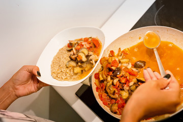 Frying pan with stew vegetables on a stove in a kitchen