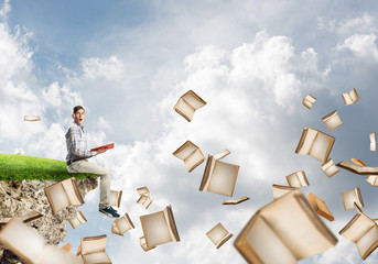 Man reading book and many of them flying in air