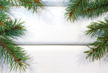 Christmas holiday background. Fir branches with space for text on a white wooden background. 