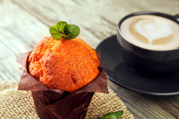 Chocolate muffins mint and coffee on wooden table