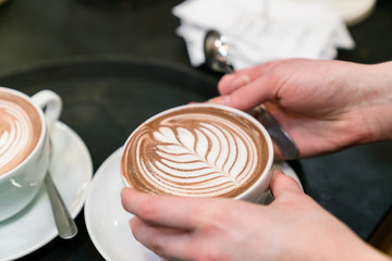 Fototapeta na wymiar latte art coffee on barista hands 