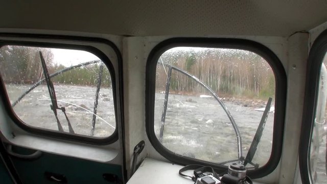 Window of airboat airglider on mountain river Temnik. Clean water and stone rock bottom in spring. Border of Baikal State Nature Biosphere Reserve. Ecotourism in Siberia of Russia.