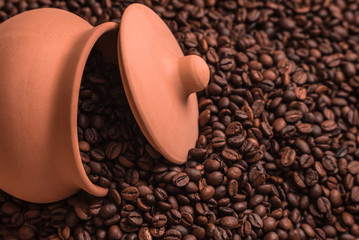 Clay pot and lid in coffee beans. Place for text or design.