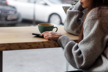 woman with mobile phone and coffee cup in cafe copy space