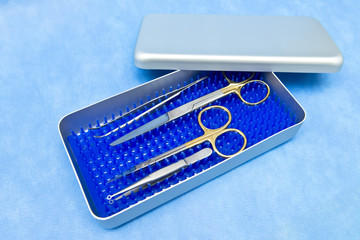 Basic surgical instruments on the sterilized blue metal tray case