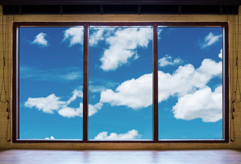 Looking through window, wooden window frames with blue sky and white clouds view