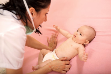 Doctor examining little baby in clinic. Baby health concept