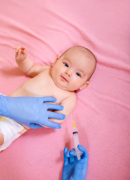 Baby receiving vaccine. Pediatrician giving a baby girl intramuscular injection in arm