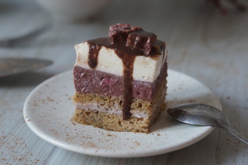 Gentle Muscovy cake with raspberry curd and poppy cakes, decorated with strawberries, chocolate, marshmallows and frosting on a light wooden background