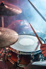 man plays the drum, flash of light, a beautiful light in the background with copy space