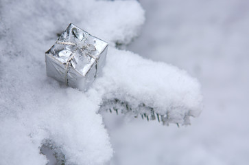 Silver christmas present on white snow.