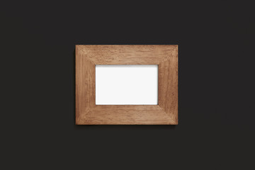 Wooden frame on black wall background