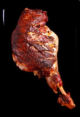 Roasted lamb leg over black background