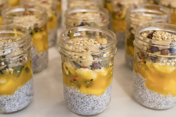 Closeup image of glass vessels with chia seeds, fruits and dry fruits.