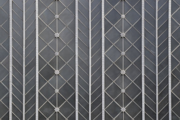 Background image of steel geometric pattern over grey glass (Madrid, Atocha train station).