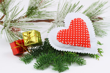 Red heart and miniature presents on fresh pine

