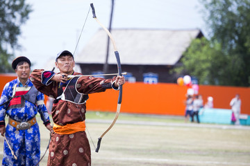 Young man shoots from a sports bow