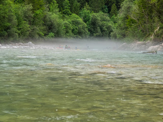 group of kayakers in the mist at the river soca, slovenia