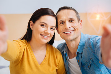 Look at us. Delighted couple expressing positivity and looking straight at camera while being happy together