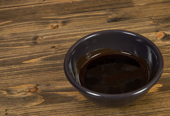 Soy sauce in the bowl on a wooden background. with copy space.