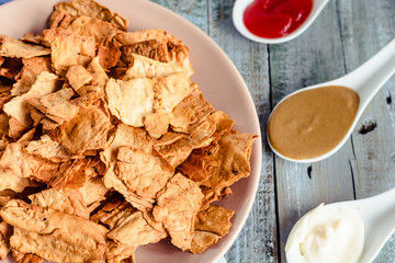 Snack for a party, healthy chips with a tortilla, nachos with sauces: salsa with tomatoes, sour cream, mustard. Mexican food.