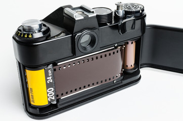 Retro photo camera 35mm with an open rear cover on white background