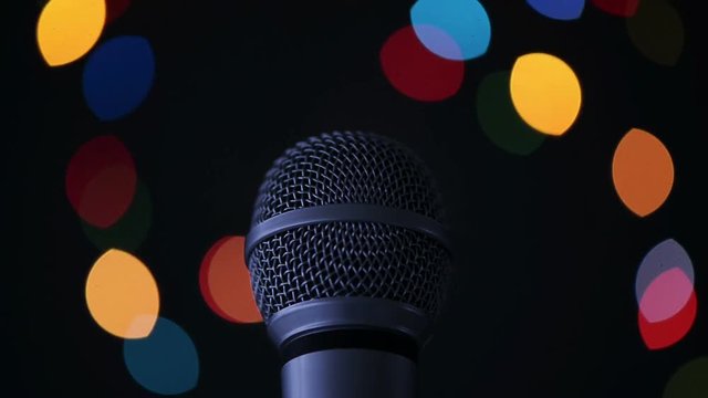Audio microphone in karaoke bar with festive bokeh light background