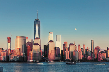 Fototapeta premium Lower Manhattan Skyline and moon rising at golden hour, NYC, USA