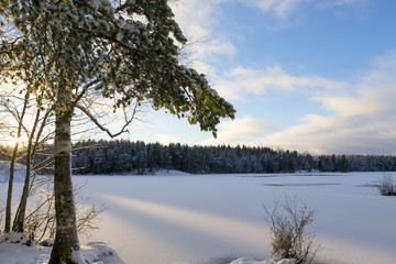 Sunrise on a winter wonderland. Snow covered lake ice with blue sky.