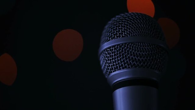 Audio microphone in karaoke bar with festive bokeh light background